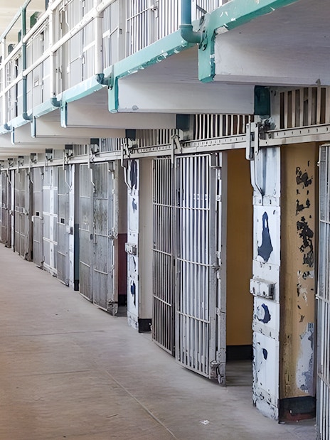 Prison cells on Alcatraz Island, San Francisco, with open barred doors and a walkway.