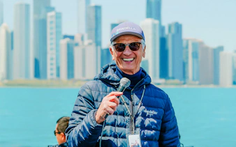 Tour guide speaking on Chicago Lake & River Architecture Tour with skyline in background.