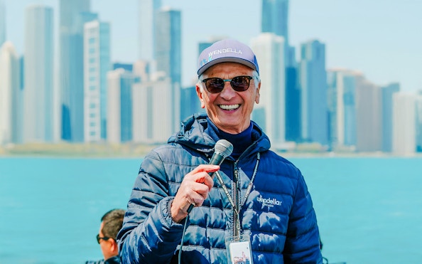 Tour guide speaking on Chicago Lake & River Architecture Tour with skyline in background.