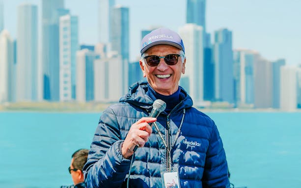 Tour guide speaking on Chicago Lake & River Architecture Tour with skyline in background.