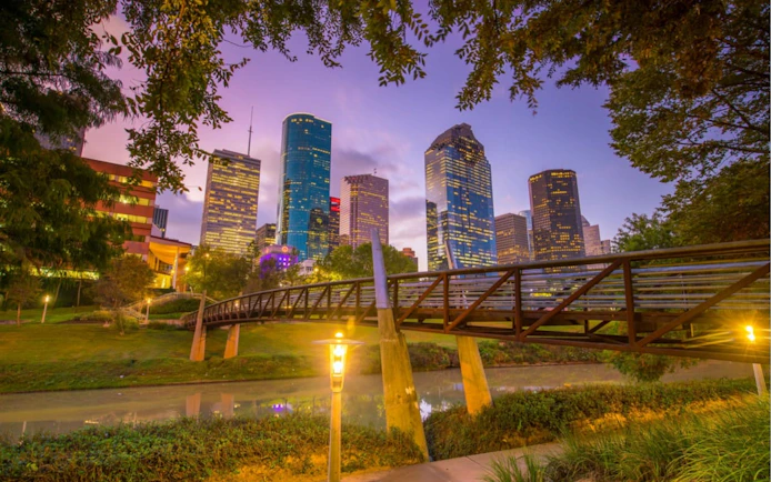 Houston skyline at dusk with a bridge over a canal, part of the Haunted Houston exploration game.