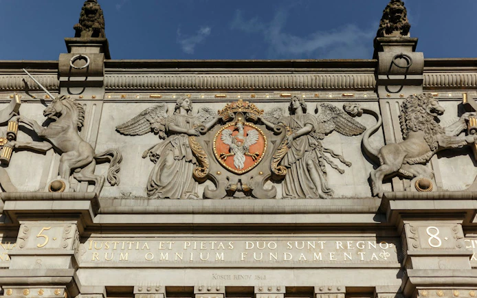 Gdansk Golden Gate facade with intricate sculptures and Polish coat of arms.