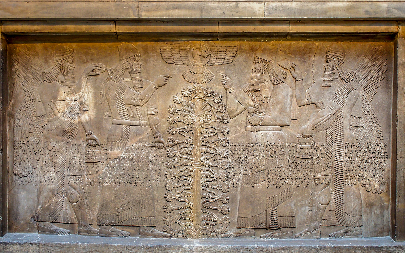 Ancient Assyrian relief depicting winged figures and sacred tree at British Museum.