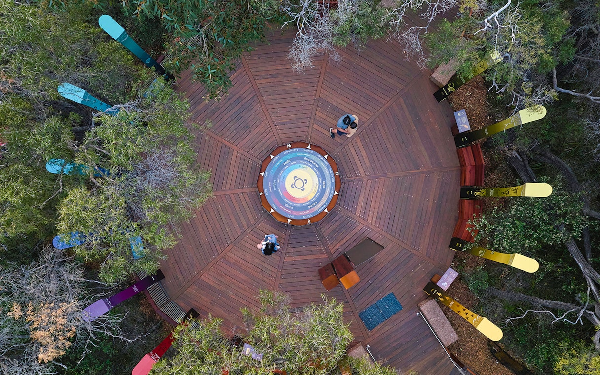 Aerial view of Ngilgi Cave Ancient Lands Experience platform with colorful directional markers.