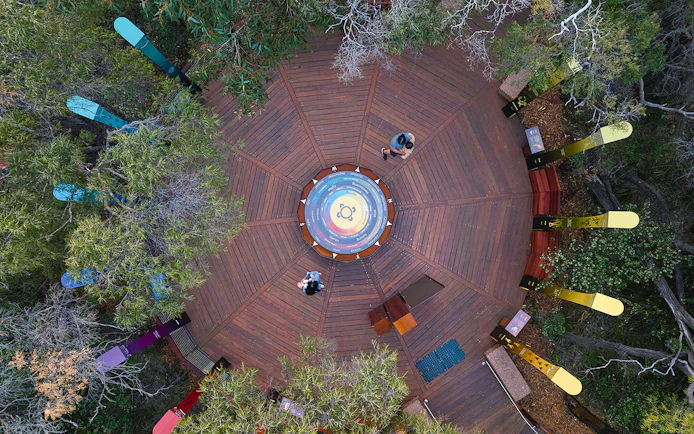 Aerial view of Ngilgi Cave Ancient Lands Experience platform with colorful directional markers.