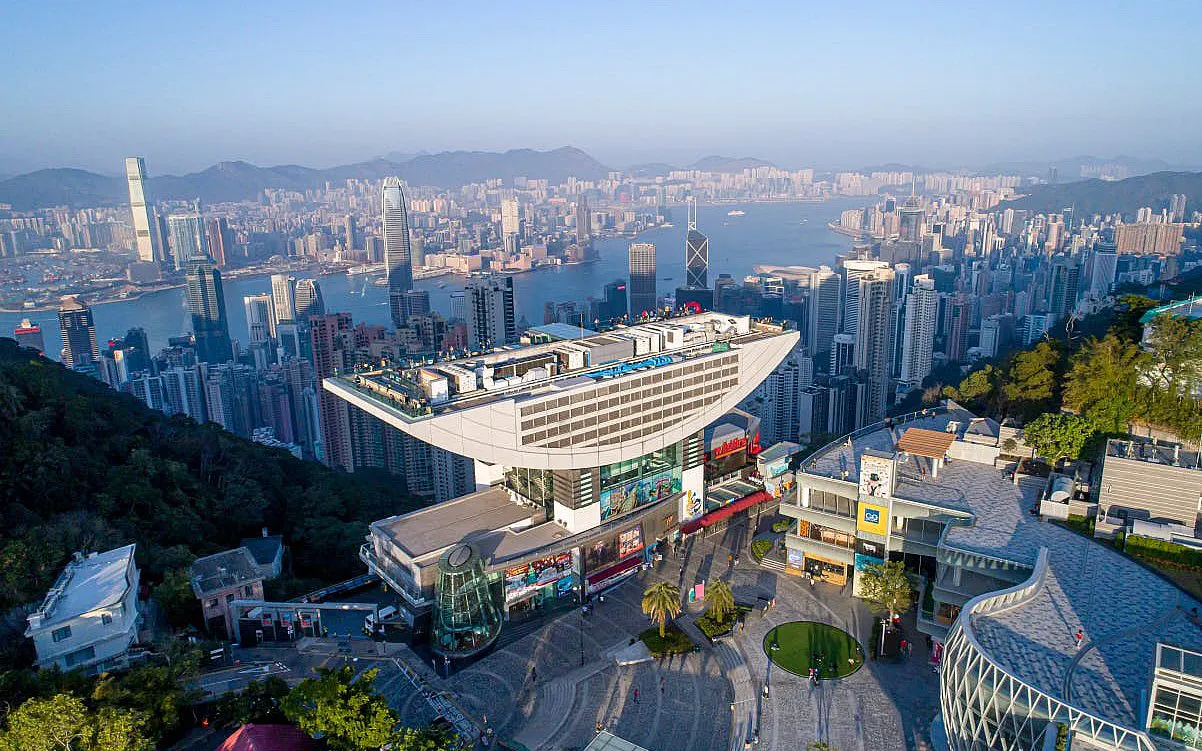 Hong Kong Peak Tower with city skyline view at sunset.