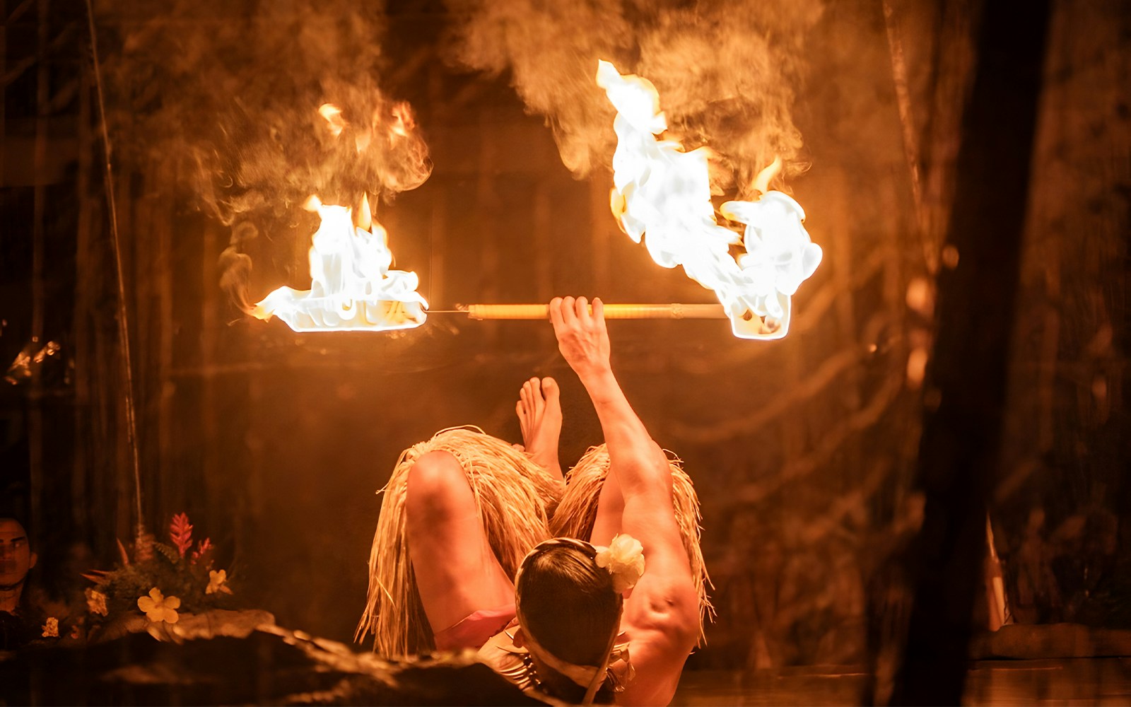 Fire dancer with fire poi twirlers at the Luau Kalamaku cultural show, Hawaii