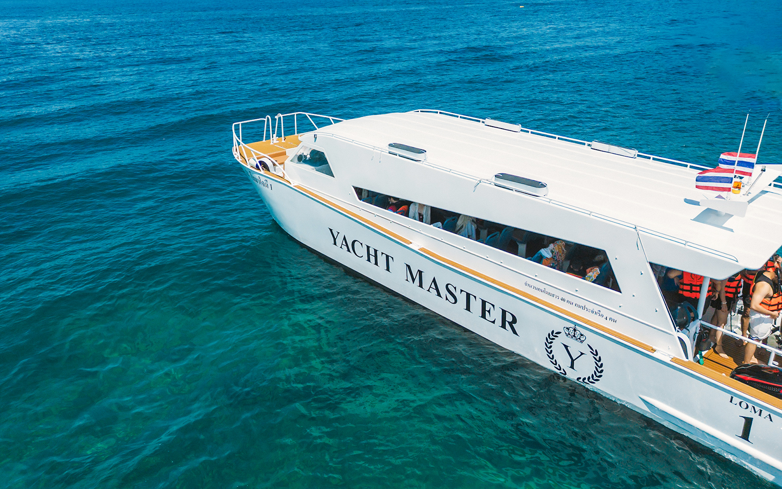 Aerial view of Premium Speed Catamaran on clear blue ocean waters.