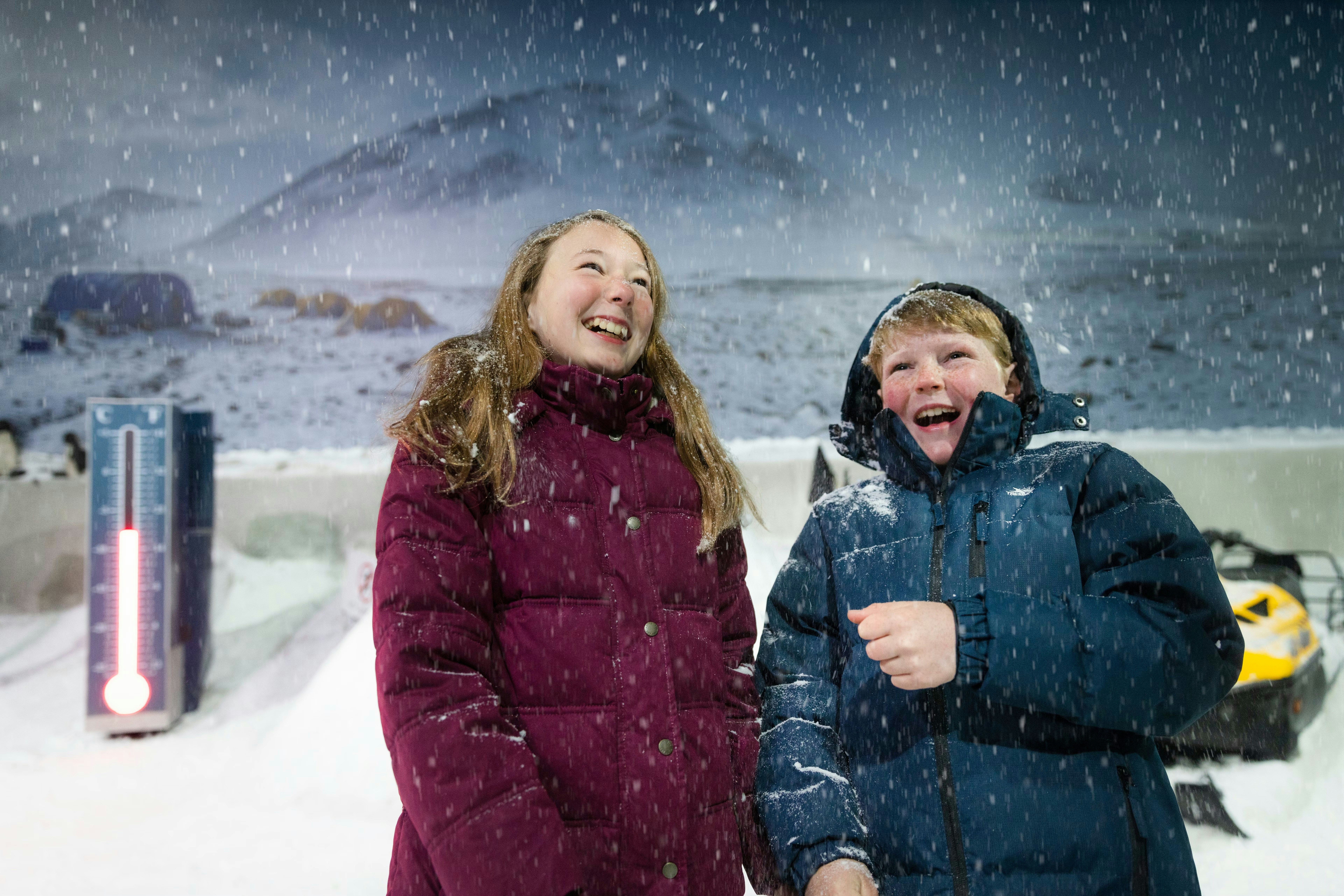Visitors enjoying snowfall in the Storm Room at the International Antarctic Centre, Christchurch.