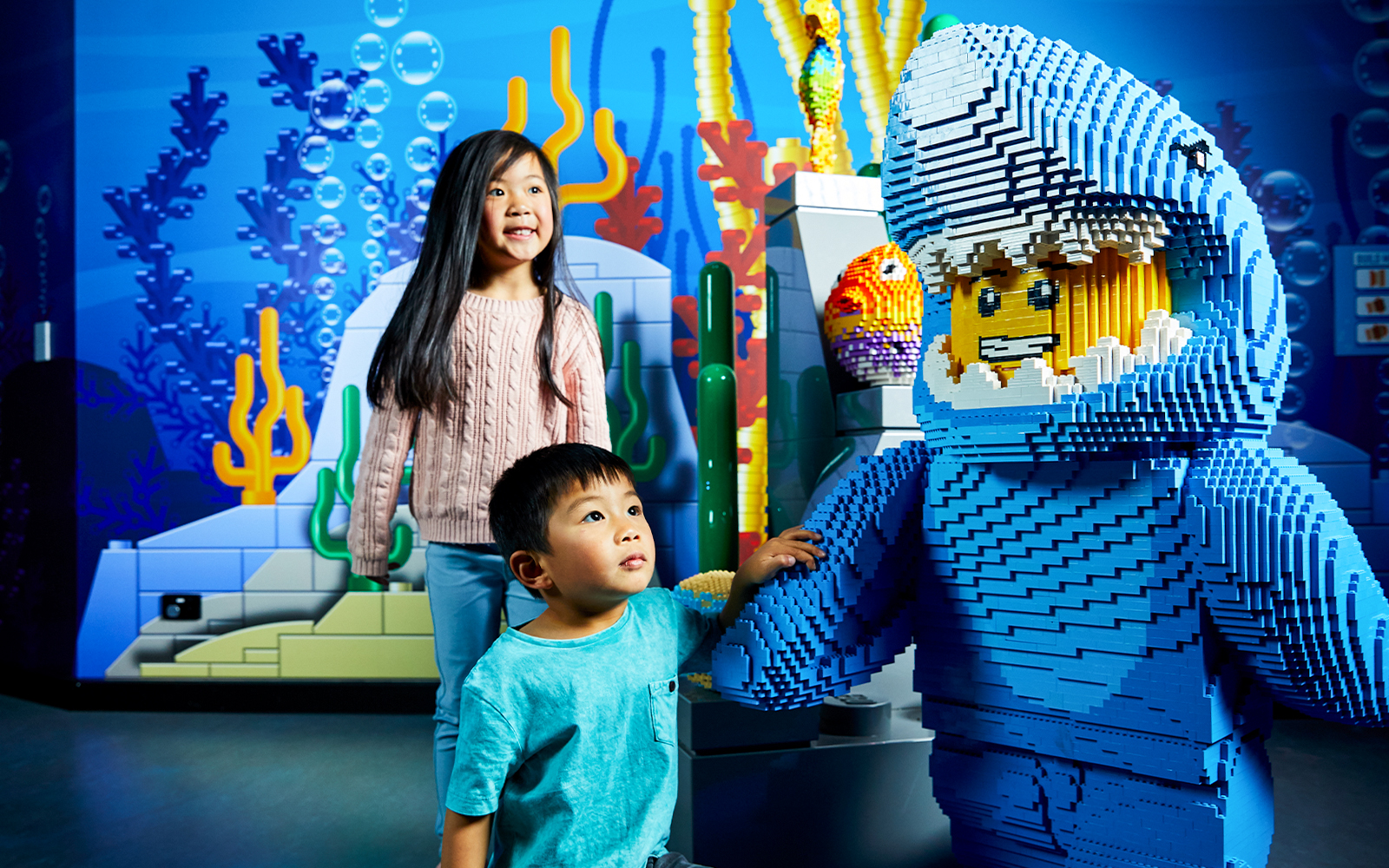 Children interacting with a LEGO shark figure at LEGOLAND Discovery Centre.