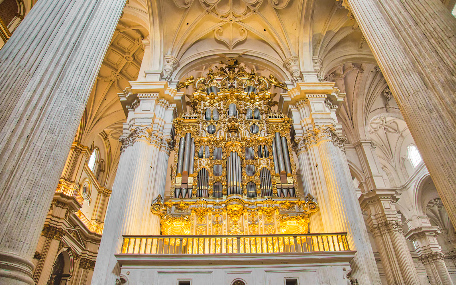Granada Royal Chapel interior with ornate golden altar and columns.