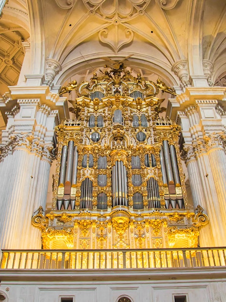Granada Royal Chapel interior with ornate golden altar and columns.