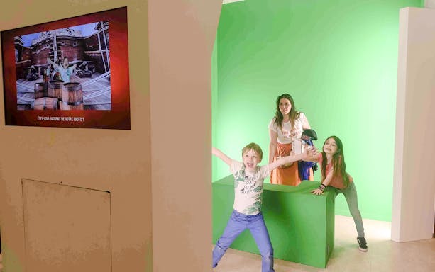 Family exploring chocolate exhibits at Choco-Story Paris museum.