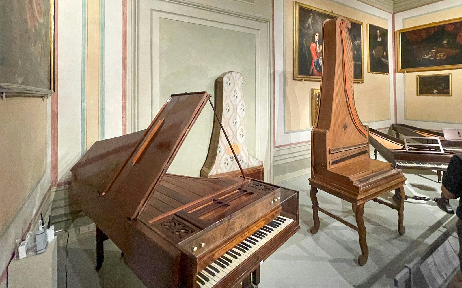 Visitors exploring musical instruments at Accademia Art Gallery's Music Museum in Florence, Italy.