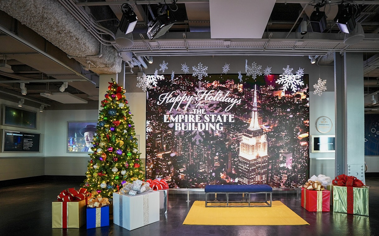Empire State Building Christmas display with tree and gifts in New York City.