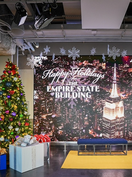Empire State Building Christmas display with tree and gifts in New York City.