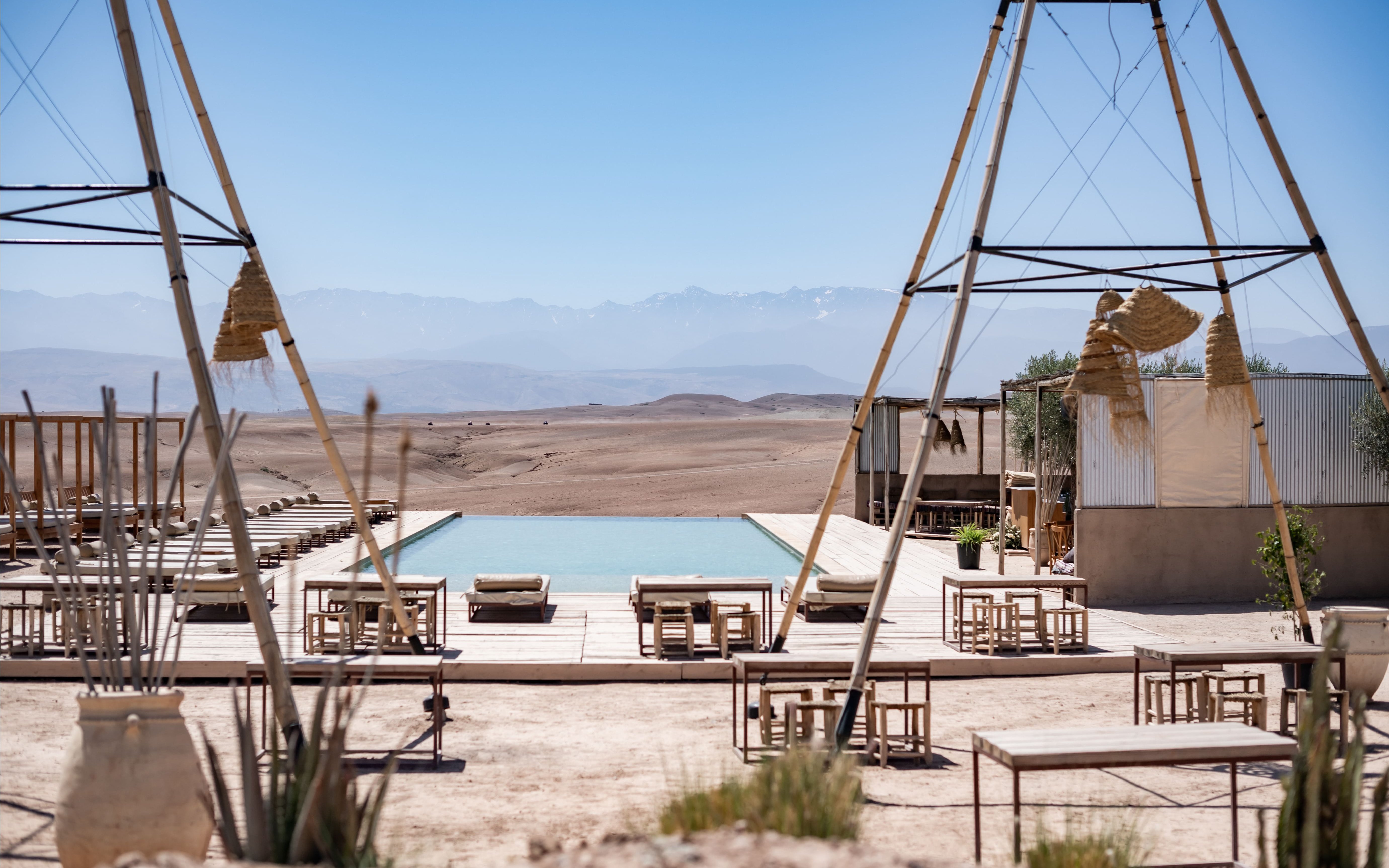 Desert camp with pool and seating at Les Terrasses d'Agafay, Morocco.