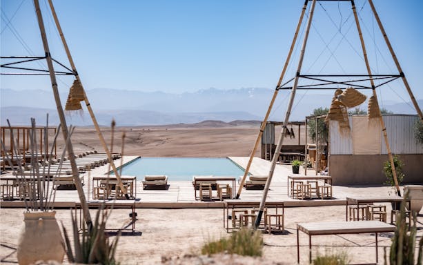 Desert camp with pool and seating at Les Terrasses d'Agafay, Morocco.