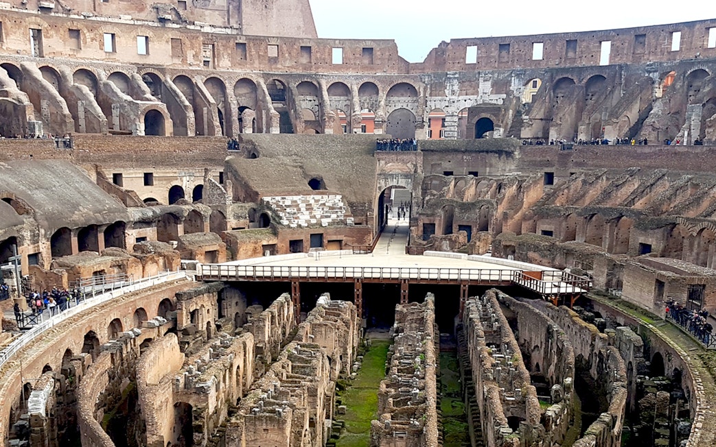 Colosseum interior view with ancient stone arches and underground chambers, Rome, Italy.