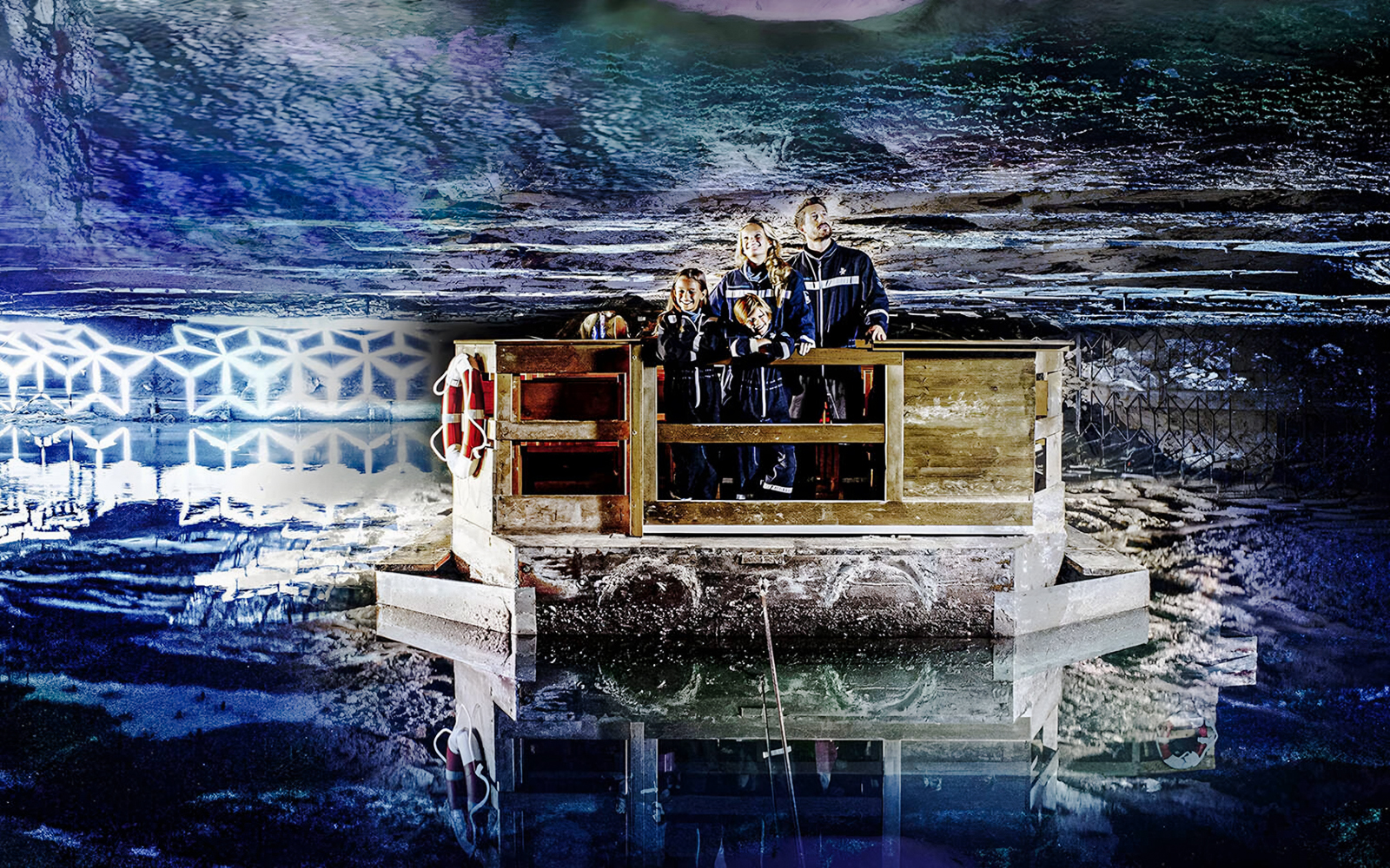 Family exploring Berchtesgaden Salt Mine on a wooden raft, Bavaria.