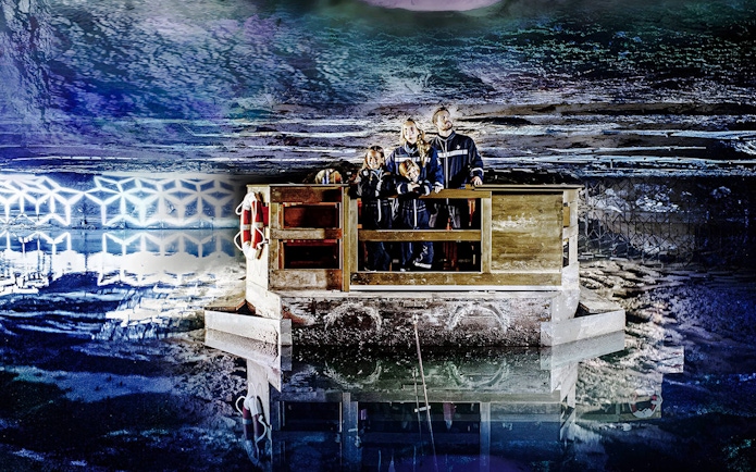 Family exploring Berchtesgaden Salt Mine on a wooden raft, Bavaria.
