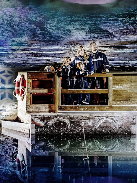 Family exploring Berchtesgaden Salt Mine on a wooden raft, Bavaria.