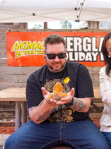 Guests holding reptiles at Everglades Holiday Park animal encounter.