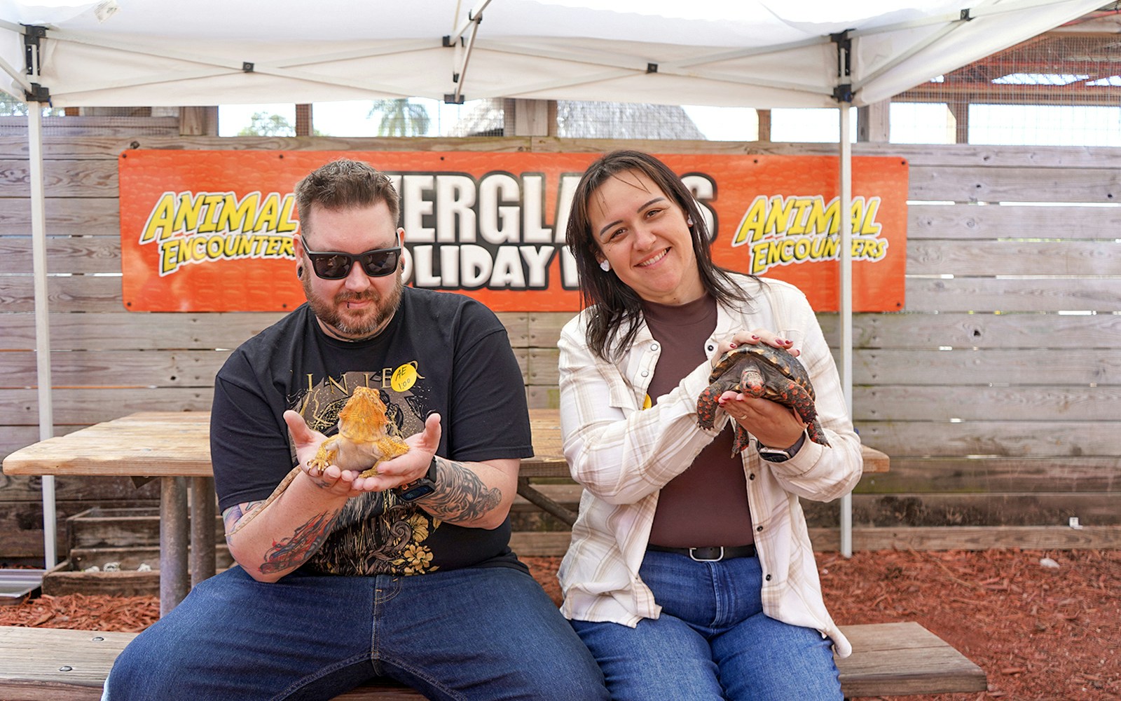 Guests holding reptiles at Everglades Holiday Park animal encounter.