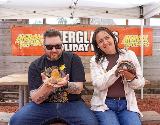 Guests holding reptiles at Everglades Holiday Park animal encounter.