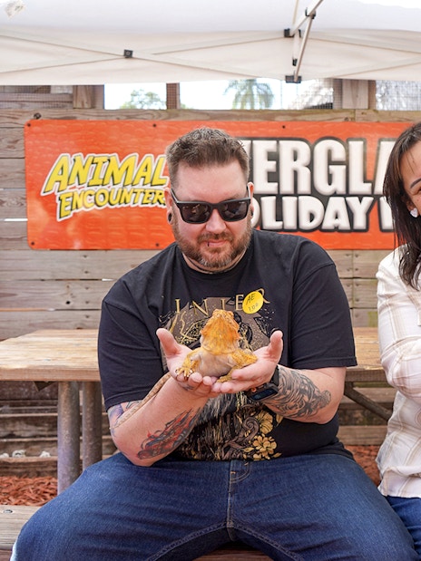 Guests holding reptiles at Everglades Holiday Park animal encounter.