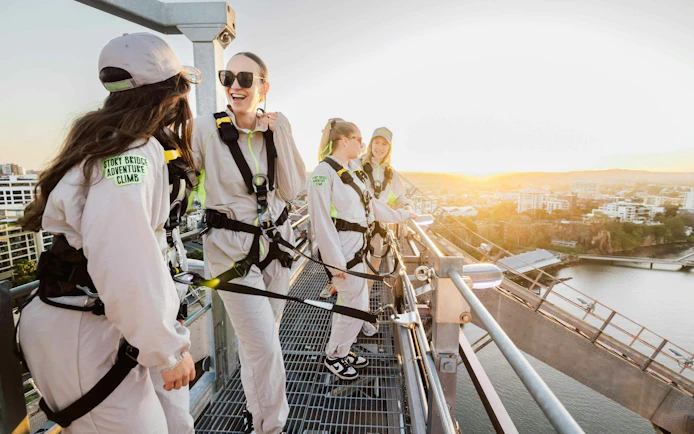 Climbers on Story Bridge Adventure Climb overlooking Brisbane at sunset.