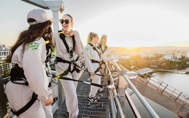 Climbers on Story Bridge Adventure Climb overlooking Brisbane at sunset.