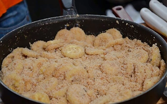 Banana slices coated in sugar and cinnamon in a pan during a Brazilian cooking class in Copacabana, Rio de Janeiro.