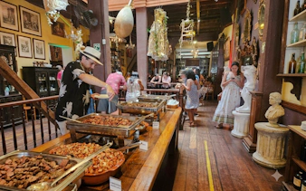 Buffet at Rio Scenarium with Brazilian dishes and patrons enjoying the vibrant atmosphere, Rio de Janeiro.