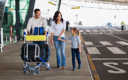 Family with luggage at Rome airport awaiting private transfer.