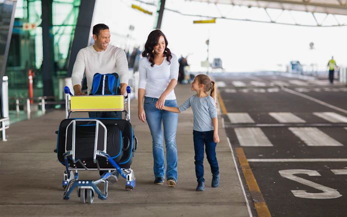 Family with luggage at Rome airport awaiting private transfer.