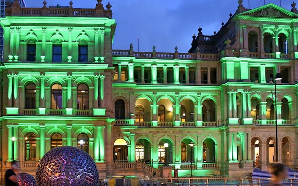 Brisbane Treasury Building illuminated at night, related to true crime stories tour.