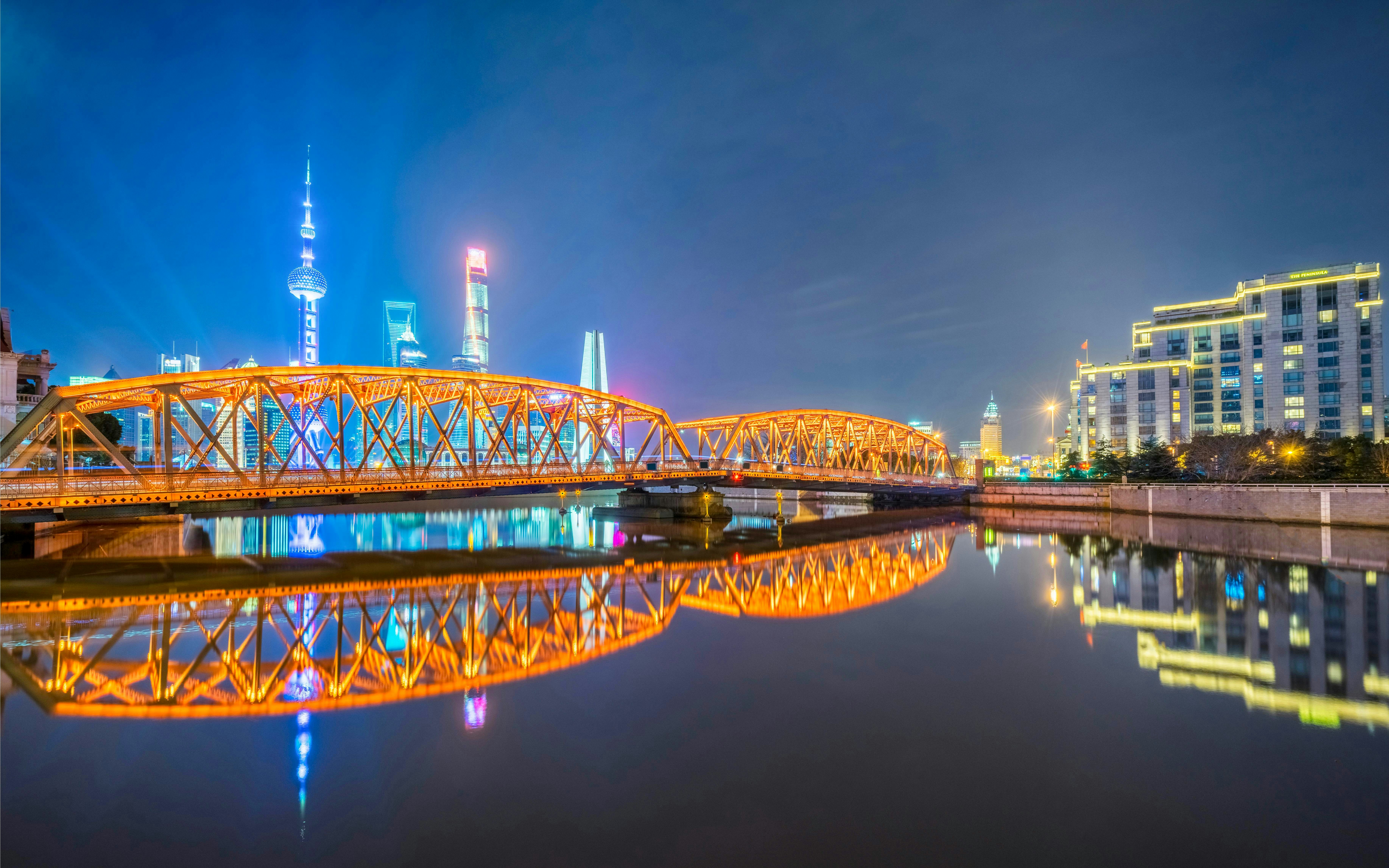 Waibaidu Bridge illuminated at night with Shanghai skyline in the background, China.