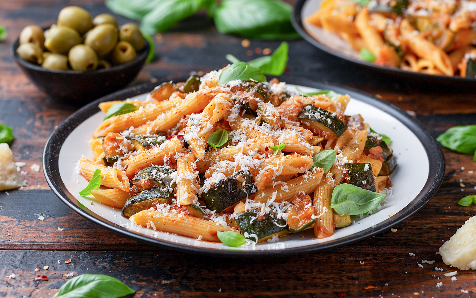 Pasta dish with zucchini and cheese, served with olives, related to Orsay Museum Tickets.