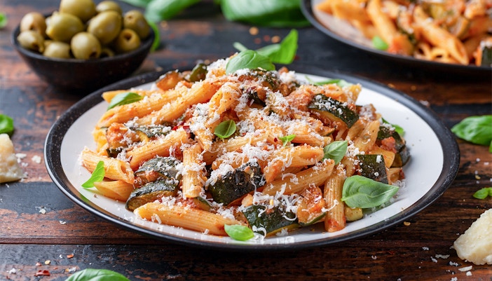 Pasta dish with zucchini and cheese, served with olives, related to Orsay Museum Tickets.