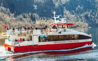 Cruise boat with passengers on Mostraumen Fjord near Bergen, Norway.