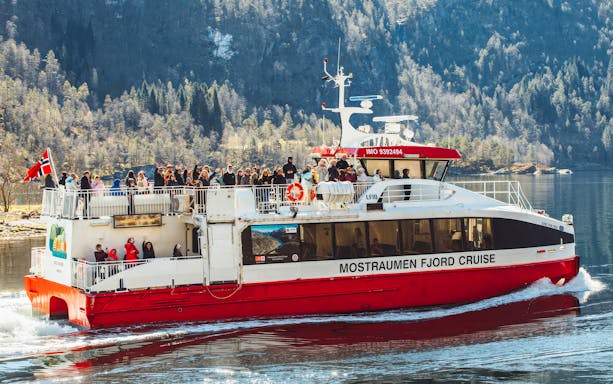 Cruise boat with passengers on Mostraumen Fjord near Bergen, Norway.