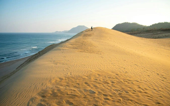 Tottori Sand Dunes with ocean view and distant mountains in Japan.