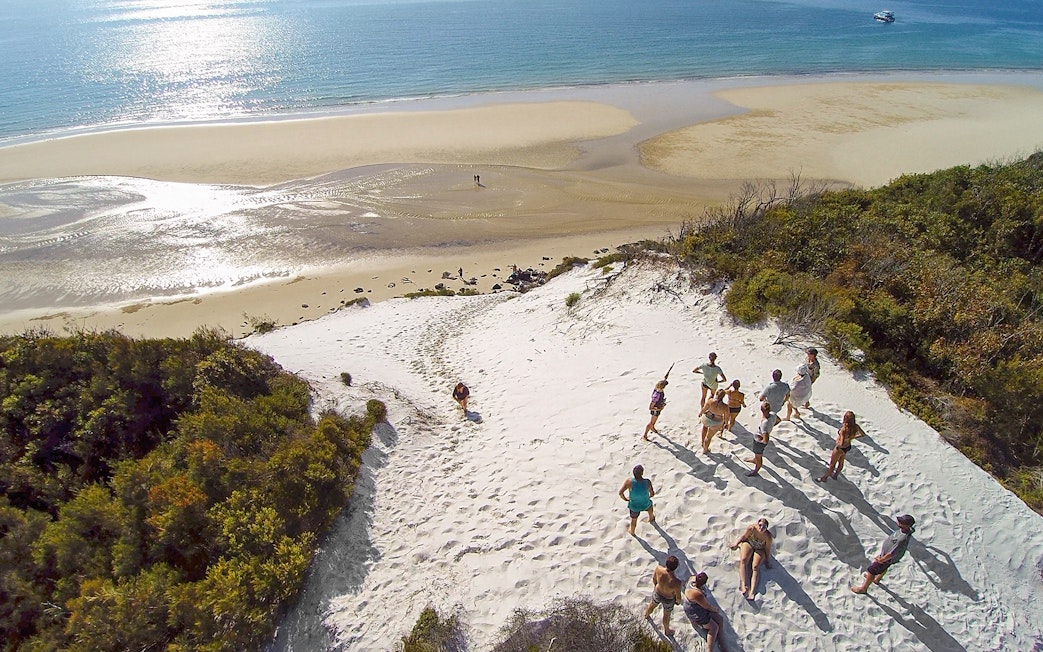 Group exploring sand dunes on K'gari (Fraser Island) during a full-day guided tour.