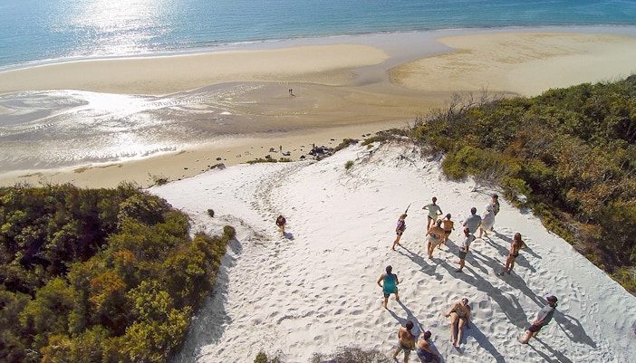 Group exploring sand dunes on K'gari (Fraser Island) during a full-day guided tour.