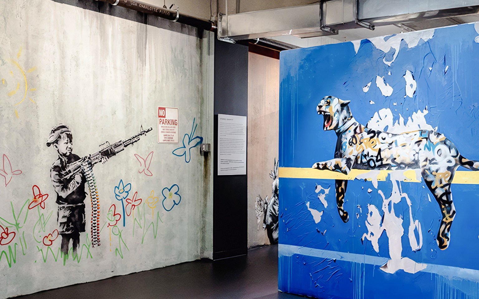 Street art at The Banksy Museum featuring a child with a rifle and a leaping leopard mural.
