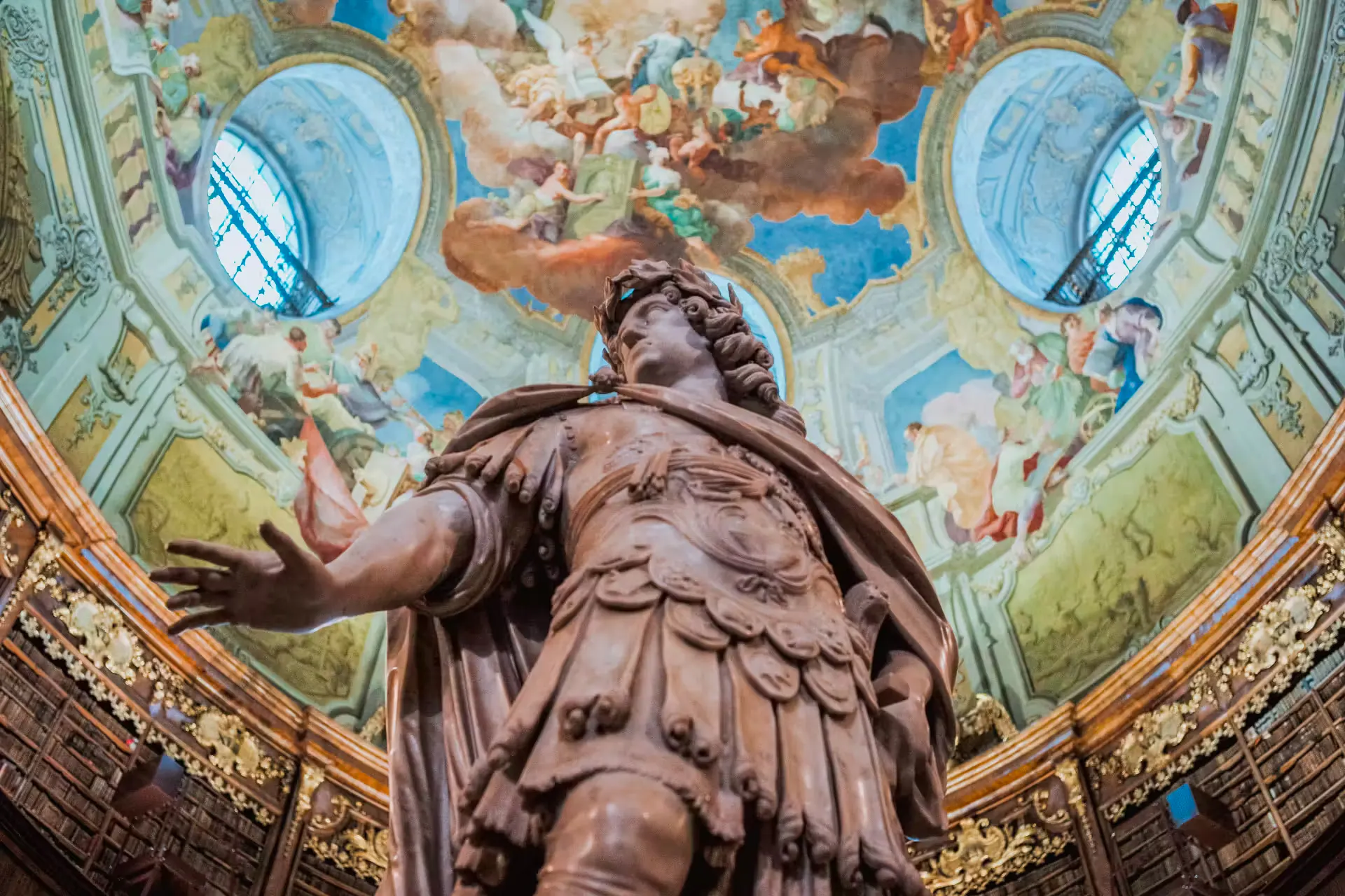 Marble statue of Emperor Charles VI under frescoed dome in State Hall, Austrian National Library, Vienna.