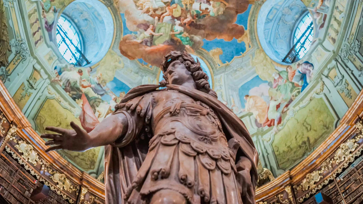 Marble statue of Emperor Charles VI under frescoed dome in State Hall, Austrian National Library, Vienna.