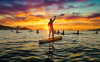 Stand-up paddleboarding at sunrise in Rio de Janeiro, Brazil.
