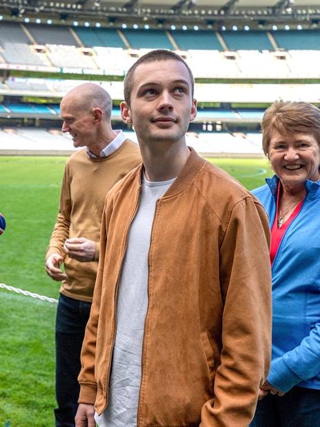 Tour group with guide at Melbourne Cricket Ground during sports walk.